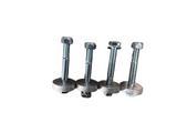 Four metal hardware components with hex bolts, nuts, and round washers arranged in a row on a brown textured surface.